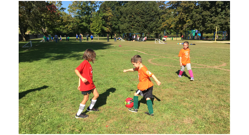 young children playing soccer